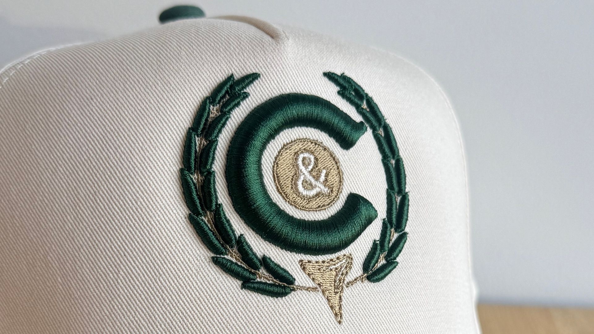 puff embroidered hat with green and gold thread